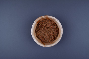 Lentils and spoon in a wooden bowl.