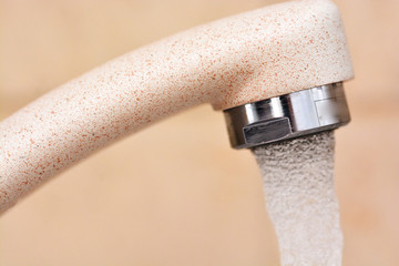 Water pouring from modern kitchen tap