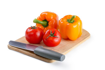 Tomatoes, pepper, knife on the board isolated on white background