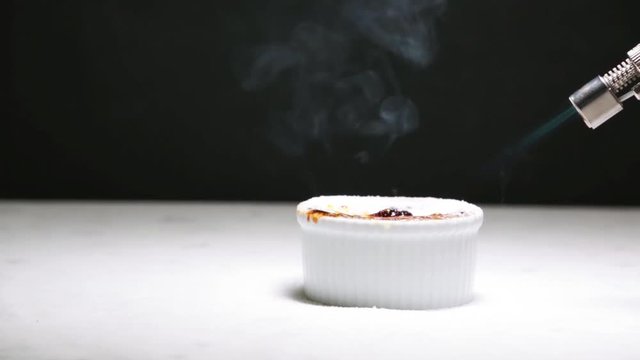 Chocolate creme brulee being caramalized from sugar to crust, with a kitchen torch, fast forward (2x speed)