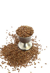 flax seeds in a small metal cup on white background,image