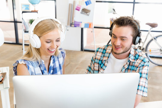 Young office workers with headphones