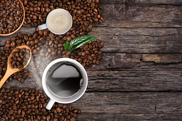 Coffee background, top view with copy space. White cup of coffee and milk, ground coffee, coffee beans on dark wooden background