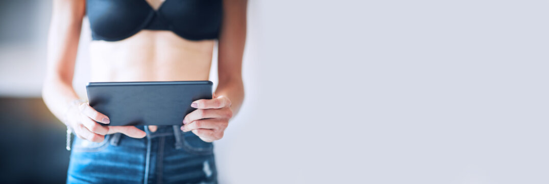 Ragazza in reggiseno fa acquisti online con tablet