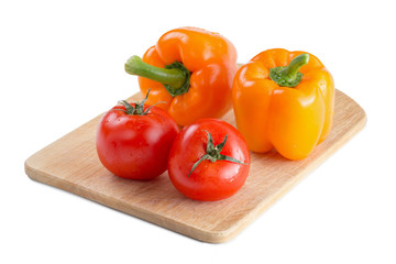 Pepper and tomato on wooden board