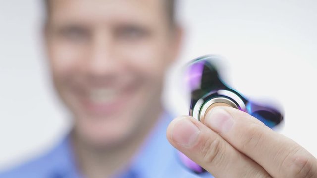 Fidget spinner rotating on hand. Man playing with fidget spinner.
