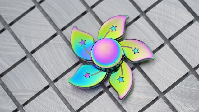 Toy fidget spiner on a  metal surface.
