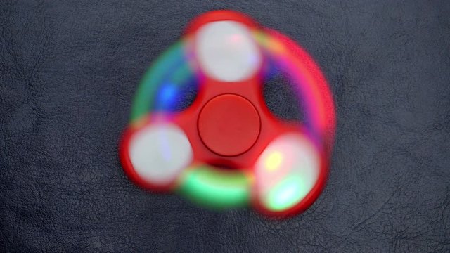 Toy fidget spinner on a  leather surface.
