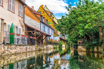 Fototapeta na wymiar Journey through small river canals and streets in the city of Colmar or small Venice, France