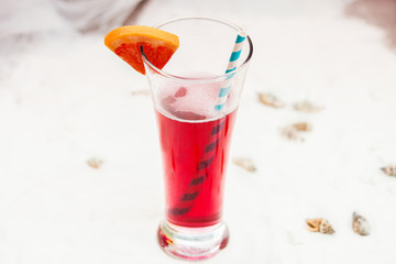 close up of red cool refreshing summer drink with straw in long glass