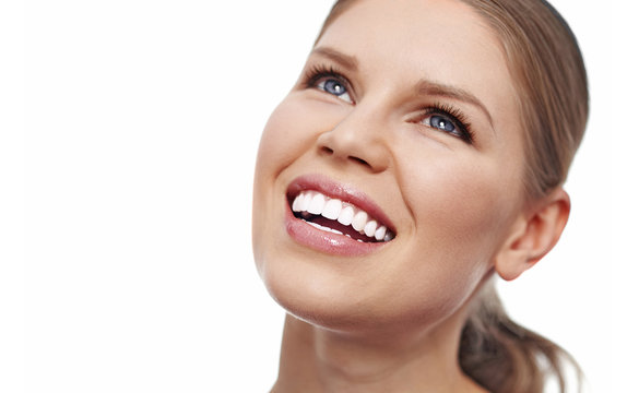Teeth whitening. Dental care. Close-up of smiling female showing her perfect healthy teeth over white background with copy space. 