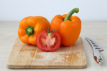 Tomatoes, pepper, knife on the board isolated on white background