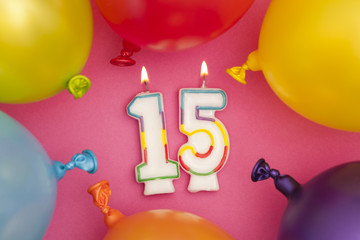 Happy Birthday number 15 celebration candle with colorful balloons