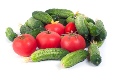 Fresh harvest of cucumbers and red tomatoes on a white background