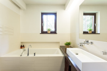 Modern white bathroom with tiled bathtub