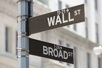 Wall Street and Broad Street corner sign near Stock Exchange, financial district in New York in a...