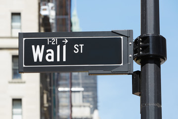 Wall Street sign near Stock Exchange, financial district in New York, blue sky in a sunny day