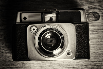 Old vintage retro camera on wooden background