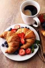 Delicious breakfast with fresh croissants, coffee and ripe berri