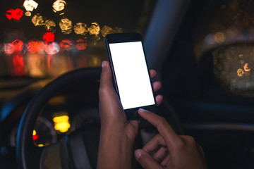 close-up hand using phone inside car on night in city