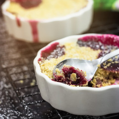 Homemade mix berry crumble in white ramekin. Healthy breakfast concept. Selective focus