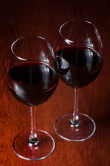 Two glasses of red wine on a dark background