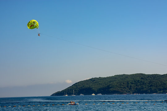 Beach entertainment. People fly by parachute