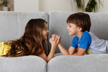 kids arm wrestling on couch