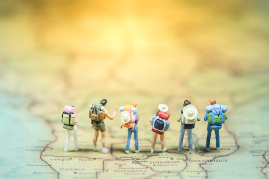 Selective focus. Miniature people : small traveler figures with backpack standing on South Africa Map / Geography of South Africa, exploring on earth background concept. - Powered by Adobe