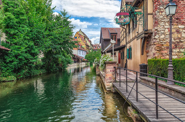 Fototapeta na wymiar Journey through small river canals and streets in the city of Colmar or small Venice, France