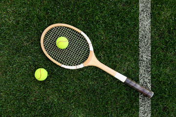 retro tennis racket on natural grass with balls. top view