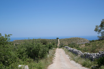 Fototapeta na wymiar Typical country road in Sicily, leading to the coast Syracuse