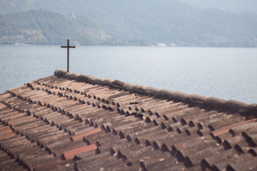 Crucifix on the roof of a church next to the lake.
Crocifisso sul tetto di una chiesa sul lago.