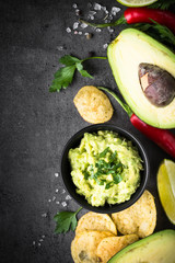Traditional latinamerican mexican sauce guacamole on black.