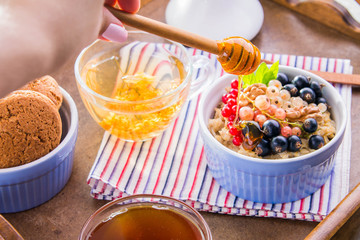 Oatmeal porridge with berries, tea and cookies for breakfast