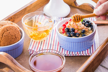Oatmeal porridge with berries, tea and cookies for breakfast