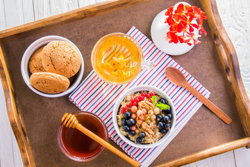 Oatmeal porridge with berries, tea and cookies for breakfast