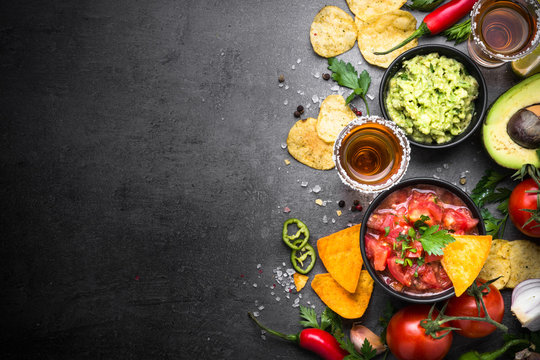 Latinamerican food party sauce guacamole, salsa, chips and tequi