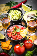 Latinamerican food party sauce guacamole, salsa, chips and tequi