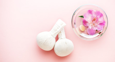 Spa. Herbal massage balls and flowers in a bowl of water