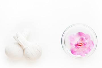 Fototapeta na wymiar Spa. Herbal Thai massage balls and flower in a bowl with water