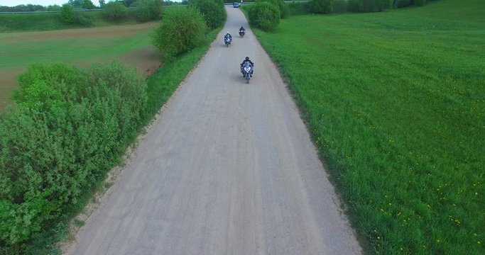 Motorcyclists touring Lithuania passes by on an enduro road bike, suited for gravel road and with pack and panniers full of supplies for traveling and camping.