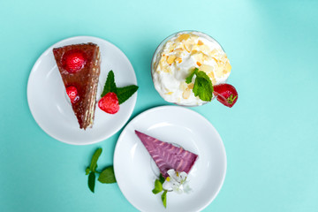 Tasty freshly baked cupcakes and colorful candies over turquoise background.