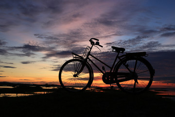Bicycle silhouette and a sunset clouds beautiful background