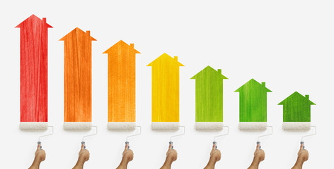 energy efficiency concept, hands with paint roller painting the colored class home and arrow chart, isolated on white background