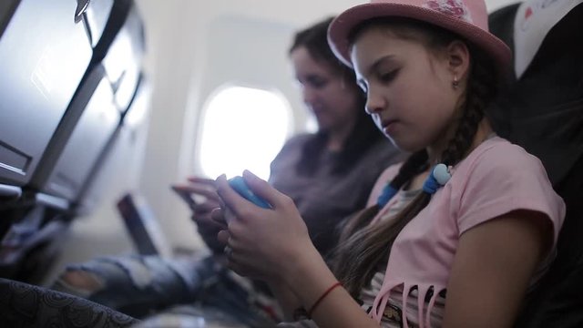 Family flies on vacation on a plane time passes through magazines and smartphones