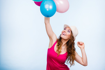 Woman playing with many colorful balloons