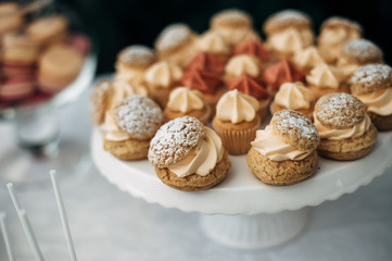 sweet bar with muffins cakes and sweets in area of wedding party
