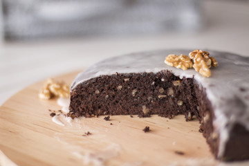 Homemade brownie cake with walnuts and white glaze close up.