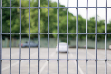 Obraz premium close up Metal grille or fence public of temporary Car Parking Stowage Barrier with blurred background. can be use as safety concept